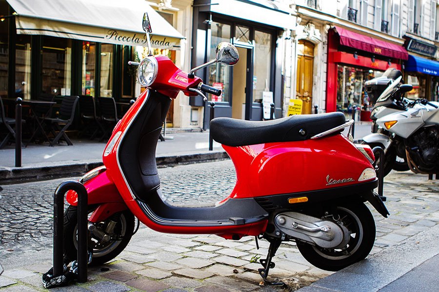 Raudona Vespa šalia italų restorano Piccola Strada Paryžiuje