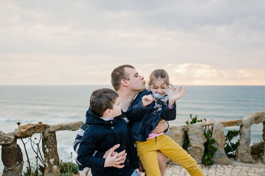 Linksma šeimos fotosesija leidžiantis saulei prie Atlanto vandenyno