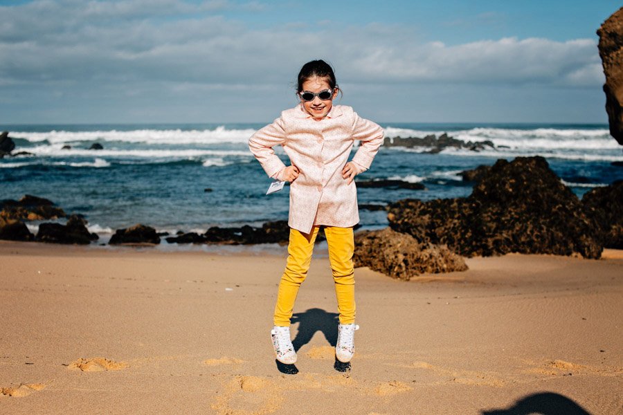 Šokinėjanti paplūdimyje mergaitė prie Atlanto vandenyno