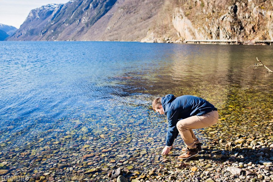 Vaikinas renka akmenukus Norvegijos fiorde