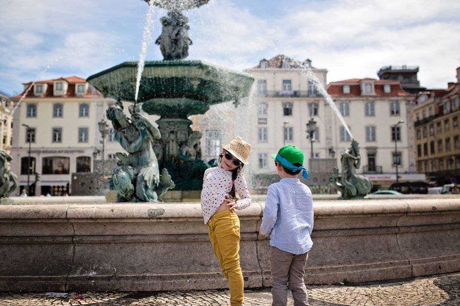 Vaikai stebisi fontanu aikštėje Lisabonoje