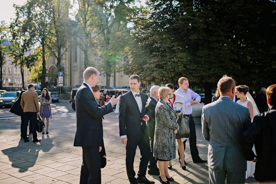 Jaunikis kalbasi su svečiais prie Vilniaus Santuokų rūmų