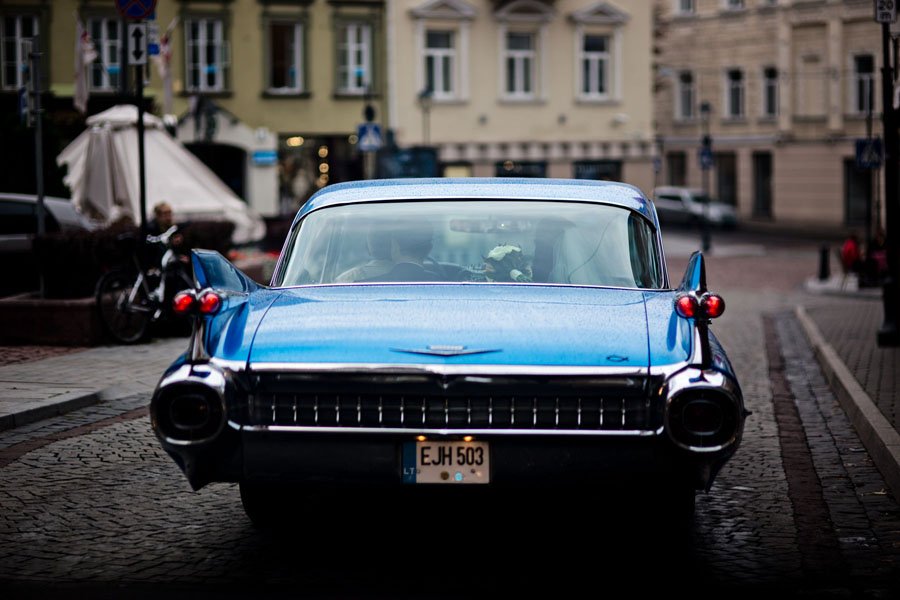 Jaunieji važiuoja mėlynu Cadillac Vilniaus senamiesčiu